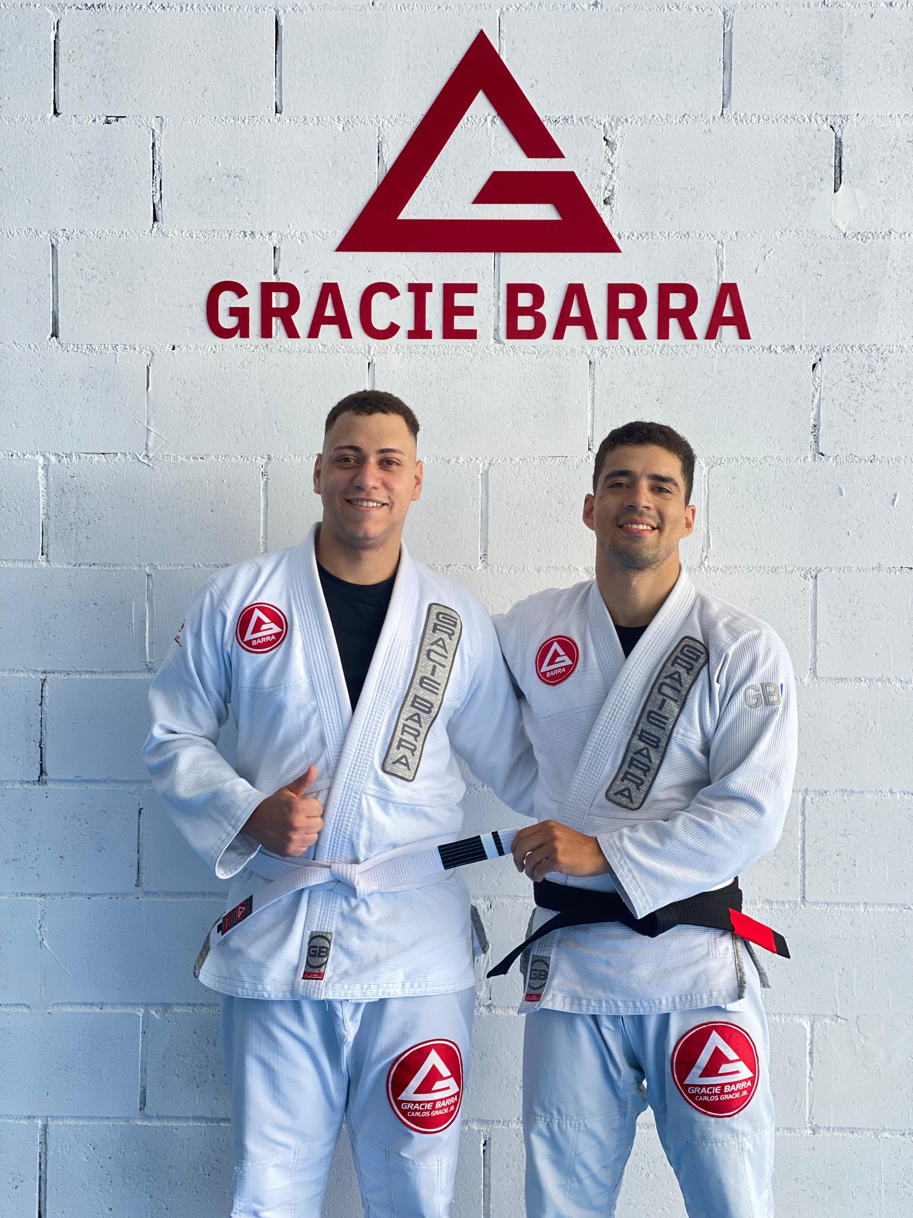Professores da Gracie Barra Caruaru em frente ao logo da academia