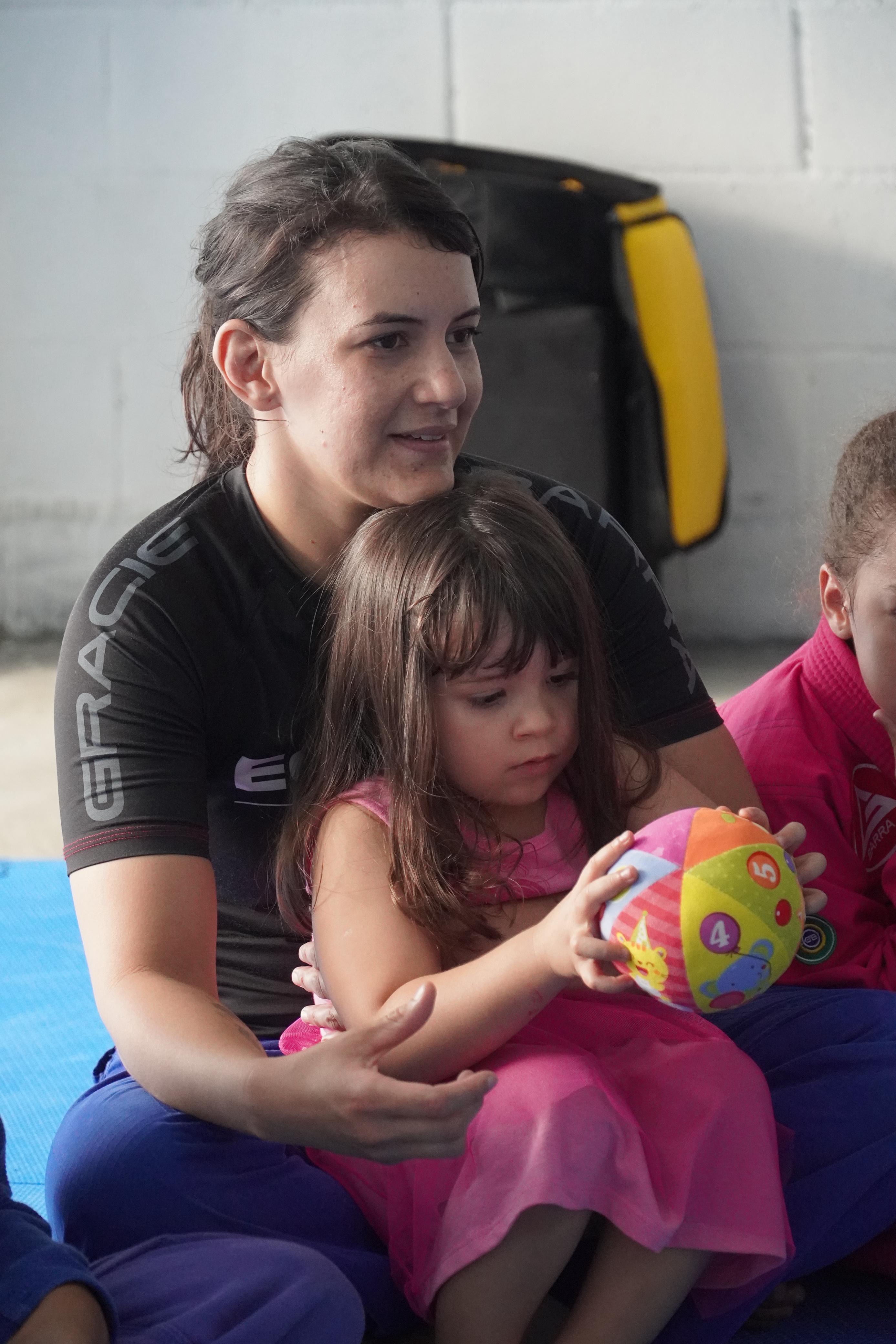 Professora Gracie Barra com criança pequena durante aula infantil na GB Caruaru